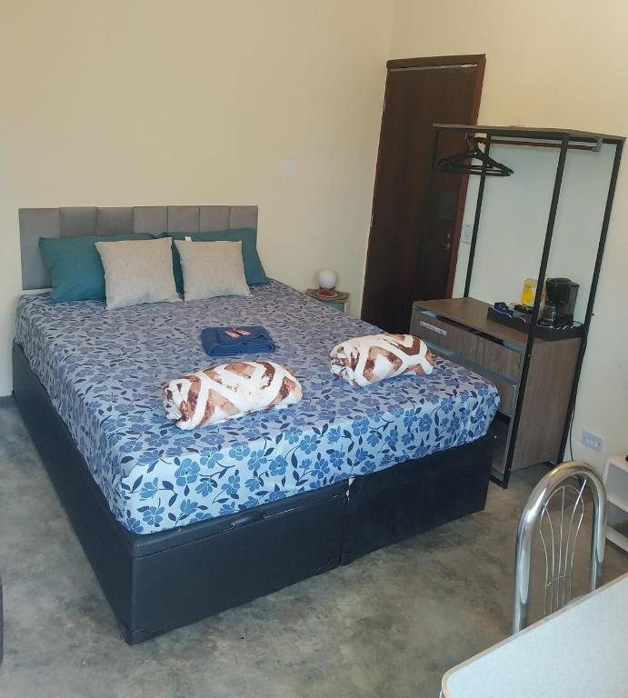 a bedroom with a bed with two animal pillows on it at Kitnet - quarto - privativo in Itupeva