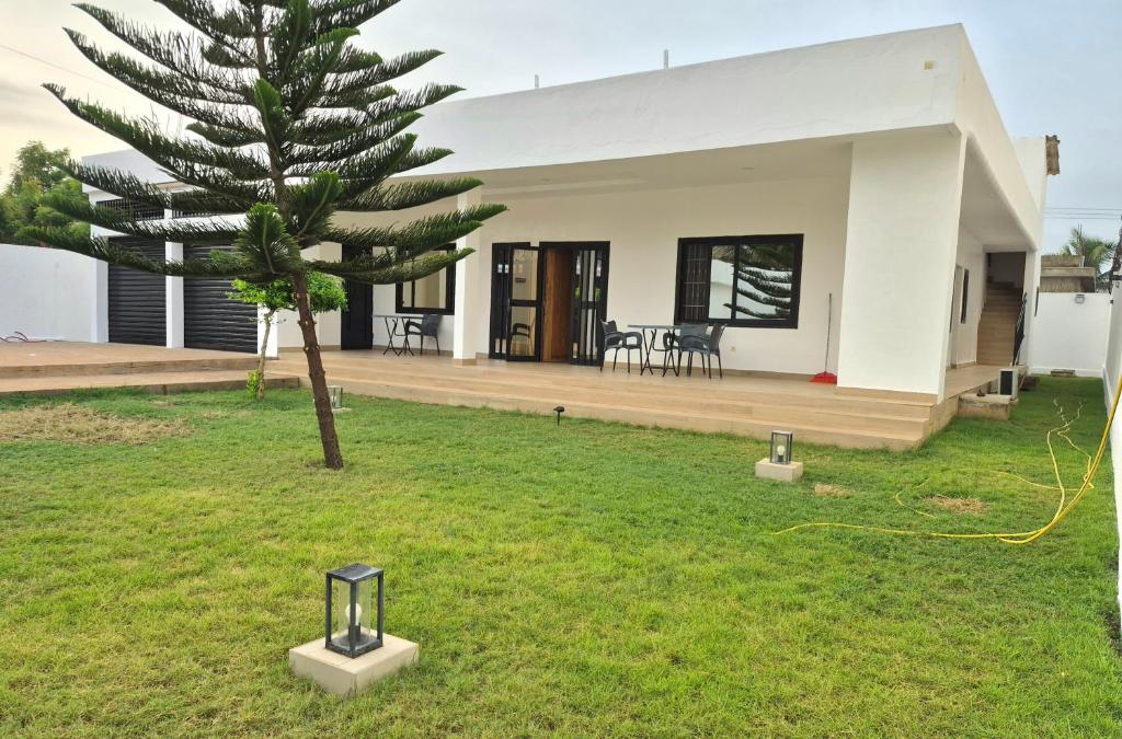 a house with a palm tree in the yard at EmElla Manor in Komé