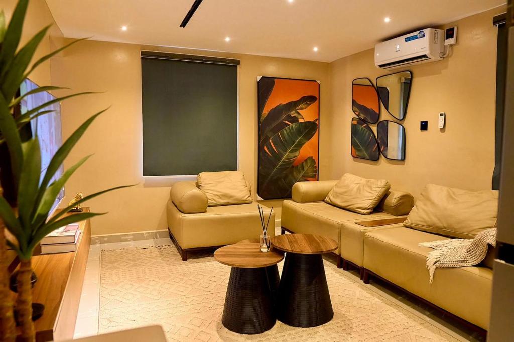 a living room with two couches and a table at Luxembourg Apartment in Lagos