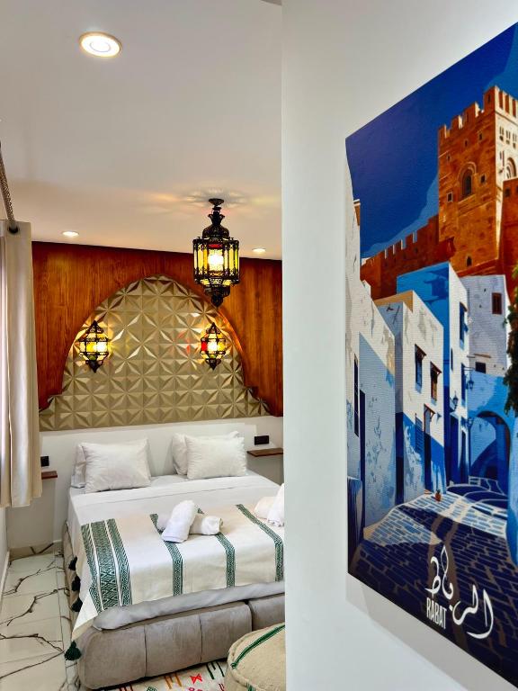 a bedroom with two beds and a painting on the wall at Riad Maison Eden in Rabat