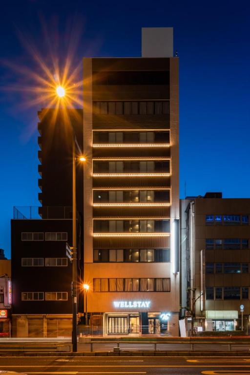 a tall building with a street light in front of it at WELLSTAY Namba in Osaka
