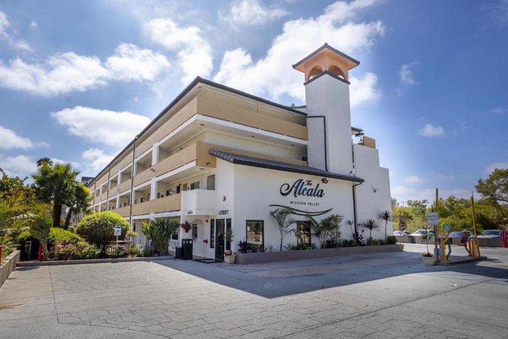 ein großes weißes Gebäude mit einem Schild darauf in der Unterkunft The Alcala Hotel Mission Valley Seaworld in San Diego