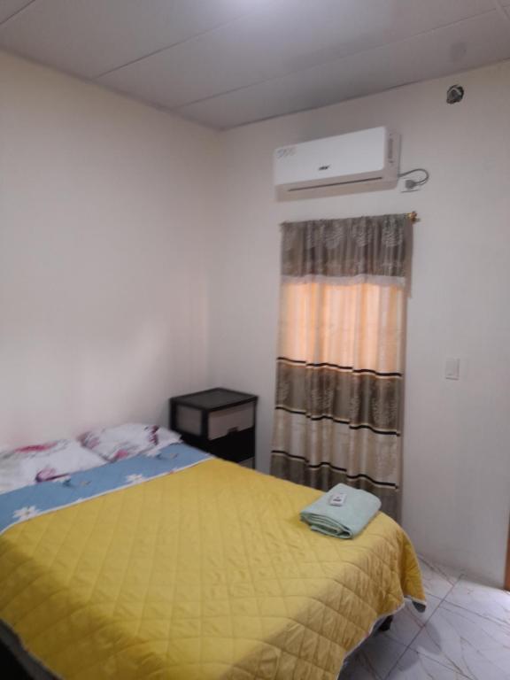 a bedroom with a bed with a yellow blanket at Mary Patsy House in Puerto López