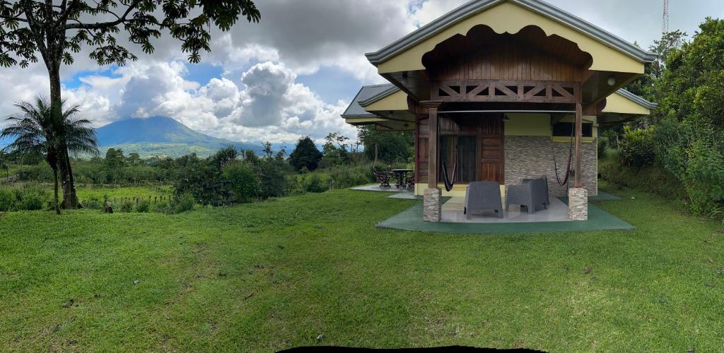a building with a table and chairs in a field at Las Pavitas Arenal Suites in Fortuna