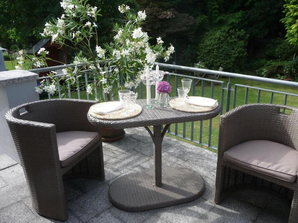 a table and two chairs with glasses on a patio at Trade fair and holiday accommodation in Oberursel