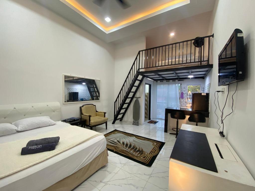 a bedroom with a bed and a tv and a living room at D'Alor Homestay in Pasir Mas