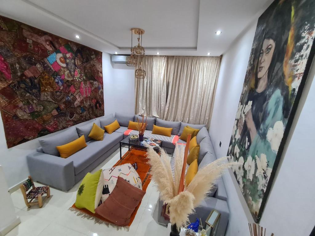 a living room with a blue couch and colorful pillows at DAR agafay in Lalla Takerkoust