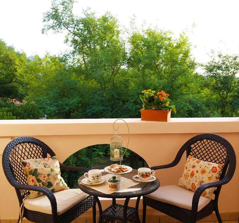 un tavolo e due sedie su un balcone con finestra di Agriturismo SaTanca ad Arbus