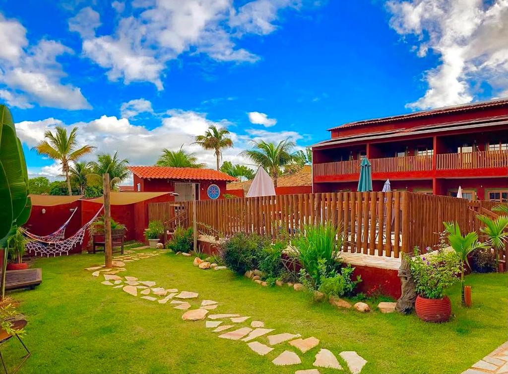 a yard with a fence in front of a house at Pousada Iandara in Pirenópolis