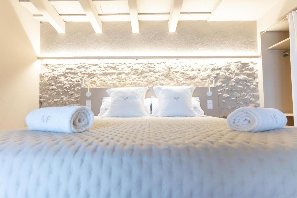a bedroom with a large bed with white pillows at Mas Pla in Riudellots de la Selva