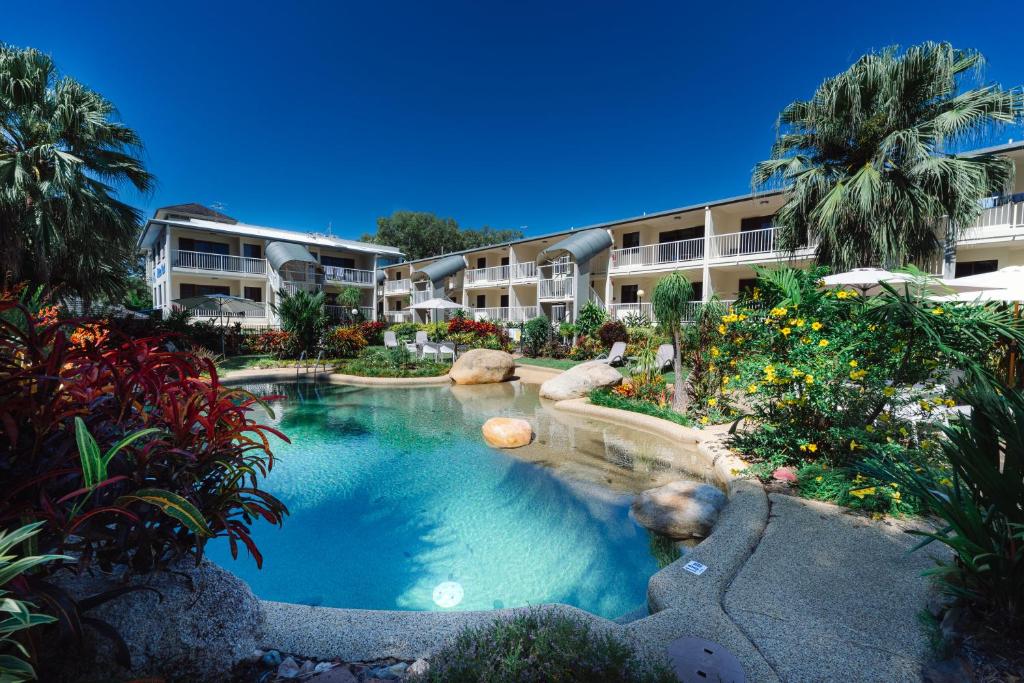 a swimming pool in the middle of a resort at Melaleuca Resort in Palm Cove
