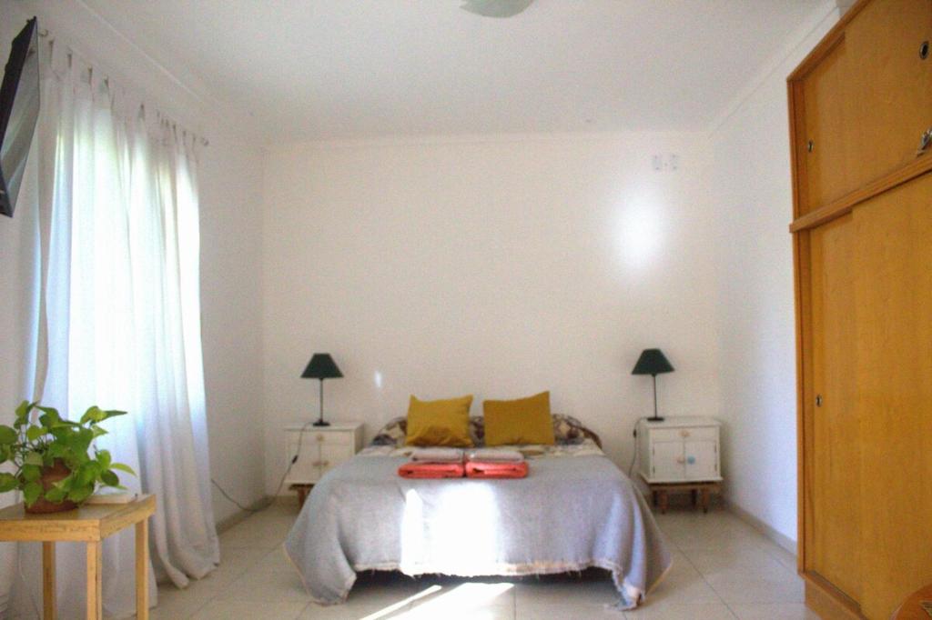 a bedroom with a bed with yellow pillows at A bright, centrally located apartment in Barraquero