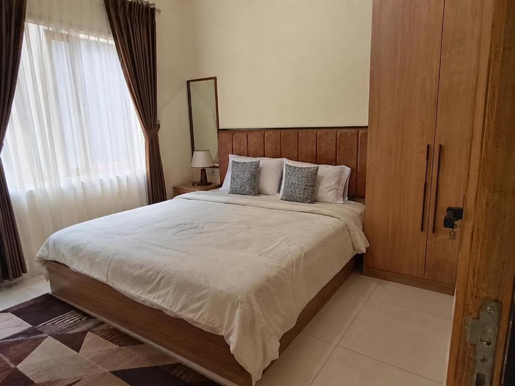 a bedroom with a large bed and a window at Olympus House Meublé Kena in San Aparicio
