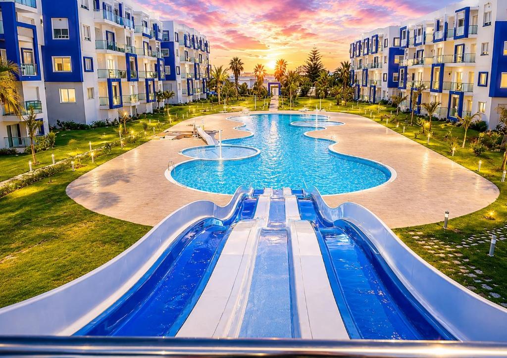 a water slide in a swimming pool in a resort at Résidence Kariat Cabo 2-bedroom apartment in Cabo Negro
