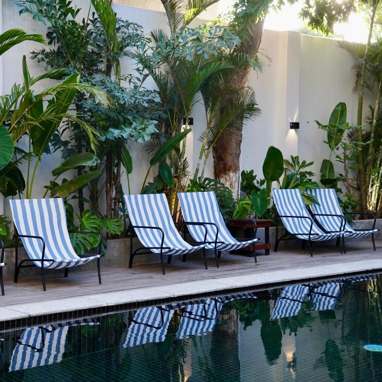 a group of chairs next to a swimming pool at The Laneway Hostel in Xuân Sơn