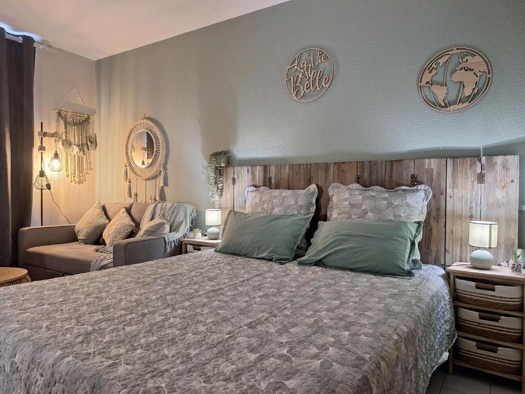 a bedroom with a large bed and a couch at Pause tropicale in Le Diamant