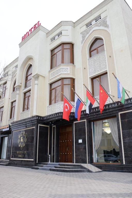 a building with flags on the front of it at Suleyman hotel in Bukhara