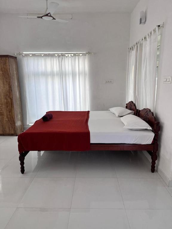 a bedroom with a large bed with a red blanket at Dver Prirody in Kovalam