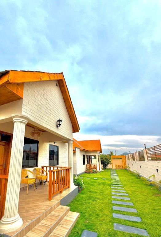 a house with a wooden deck and a yard at JND Cozy Homes in Iringa