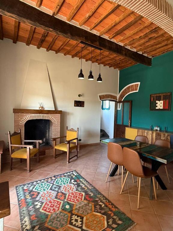 a living room with a fireplace and a table and chairs at Villa Gopal Natura Toscana vicino Lucca 7 posti in Capannori