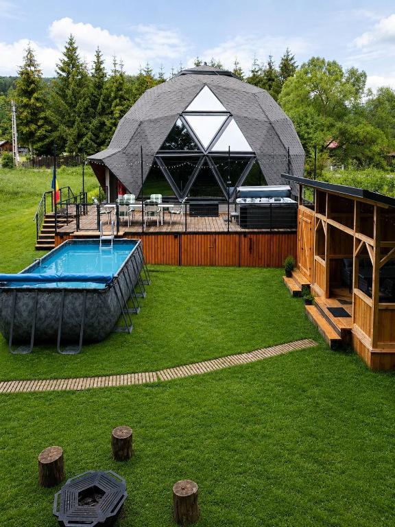 a large tent with a pool in a yard at Exclusive Dome Valea Doftanei in Trăisteni
