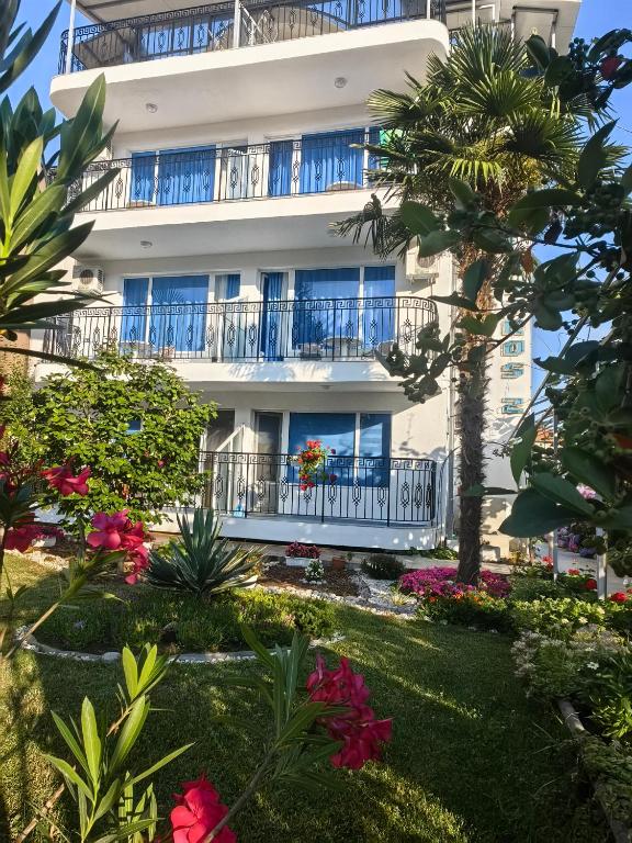a building with balconies and flowers in a garden at Albatros 2 Family Hotel in Kiten