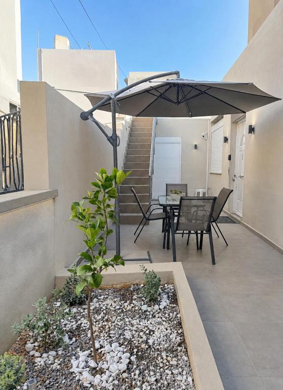 a patio with a table and an umbrella at Villa Irene in Heraklio