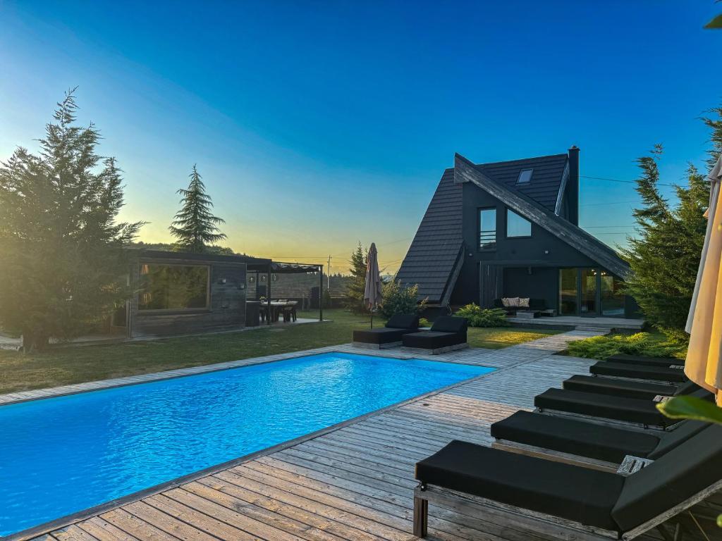 a swimming pool in front of a house at Zoe Luxury House in Gomirje