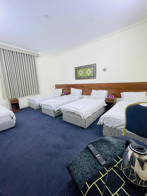 a hotel room with three beds and a couch at فندق دار العوالي3 in Medina