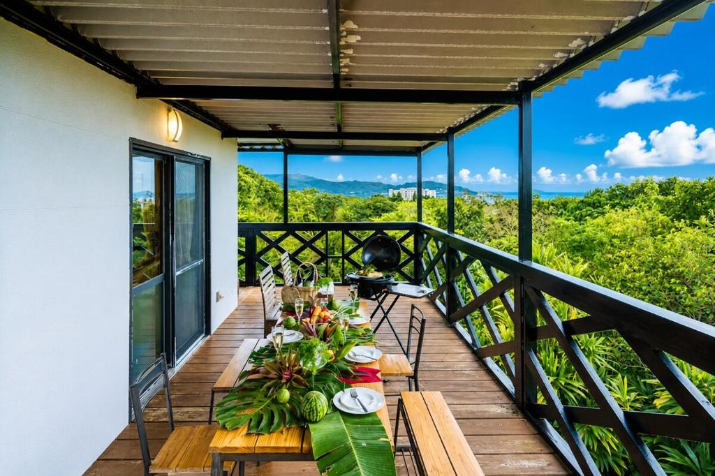 a table on the balcony of a house at 美ら海水族館まで車4分の一棟貸ヴィラちゅらジャングルリゾート in Motobu