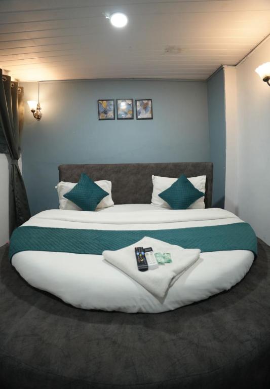 a large bedroom with a large bed with green pillows at The Highstreet Legacy in Pune