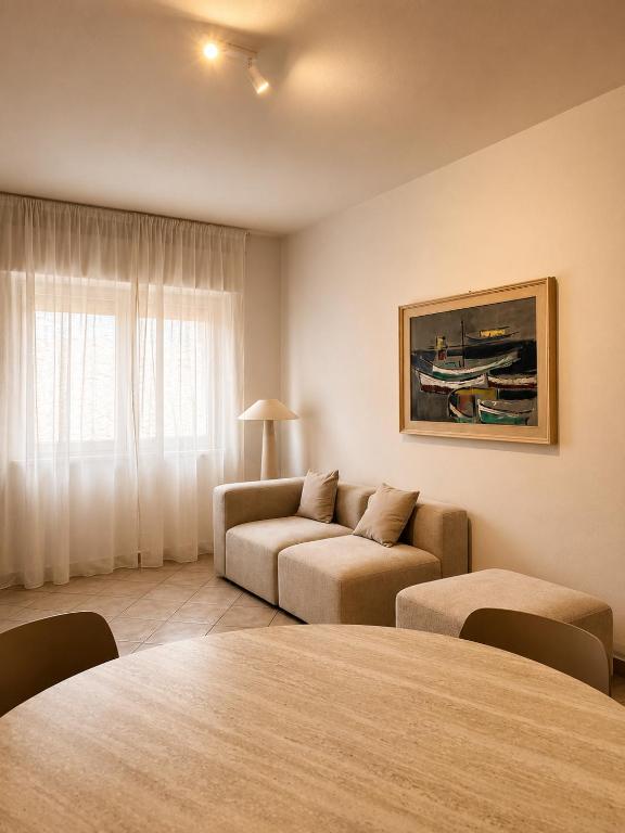 ein Wohnzimmer mit Sofa und Tisch in der Unterkunft Ā - Living in Valledoria