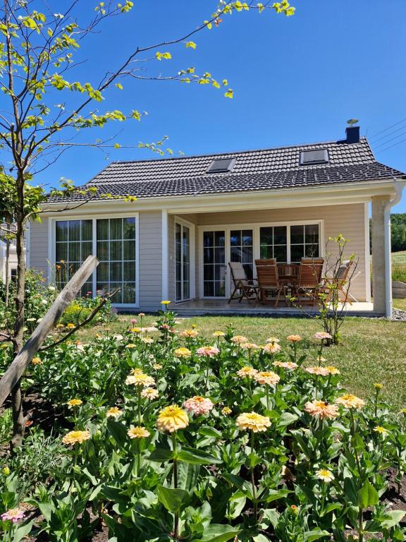 a house with flowers in front of it at Seventh Heaven Village Glamping in Rogašovci