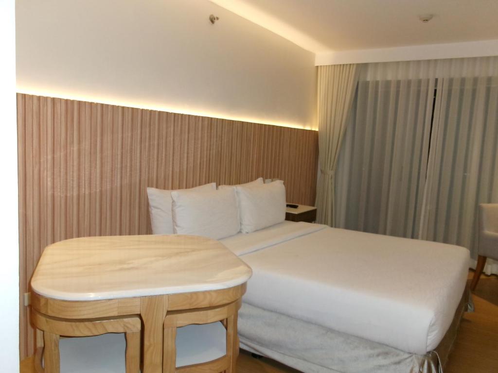 a hotel room with a bed and a table at Alasra Suites in Ulot