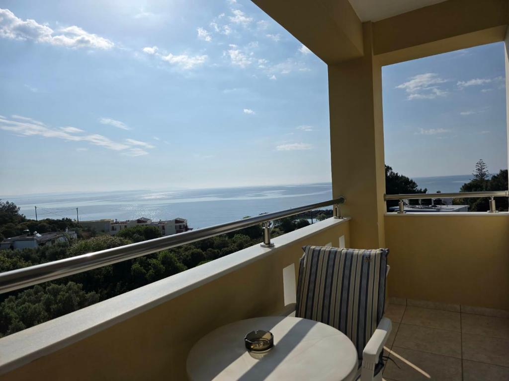 a balcony with a chair and a view of the ocean at Yolanda Studios in Paralia Agias Foteinis