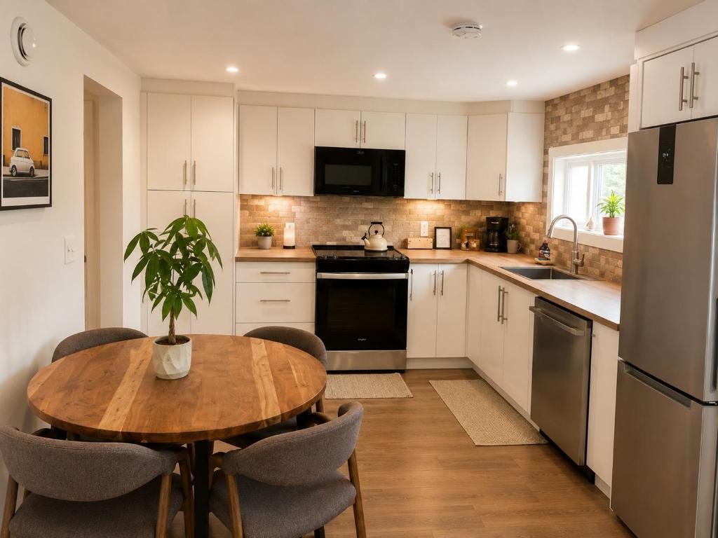 a kitchen with white cabinets and a wooden table with a potted plant at Okanagan Valley Beautiful 2 beds 2 bath in Vernon