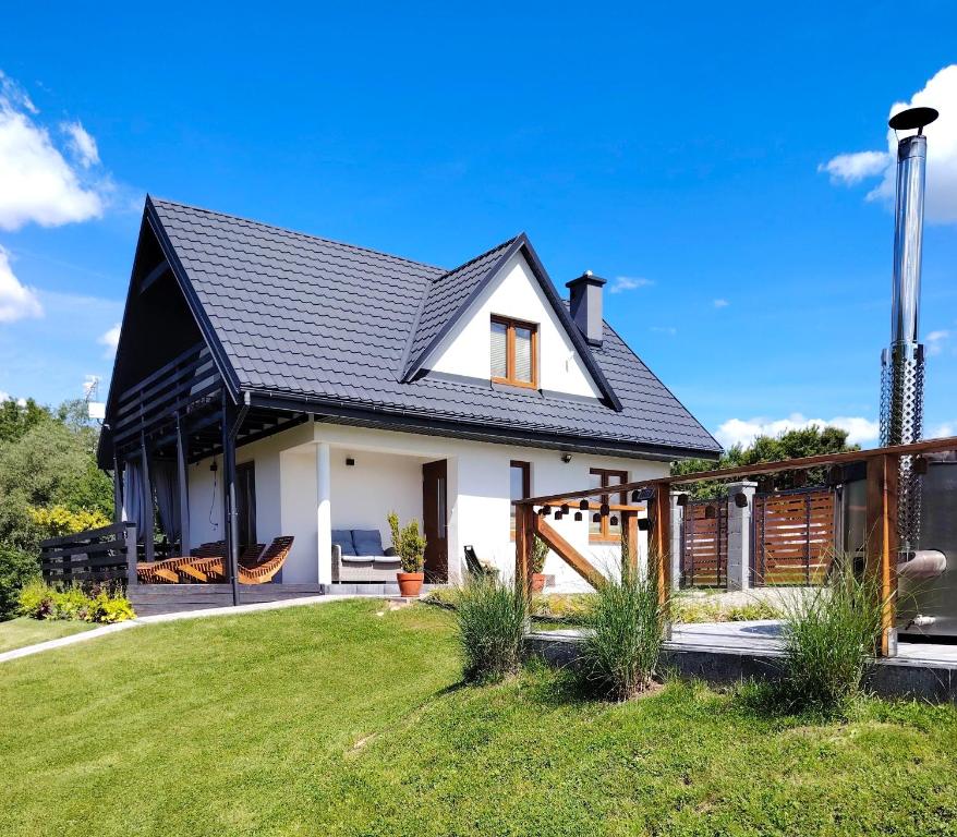 a white house with a black roof at OdpocznieszTU in Brzozowa
