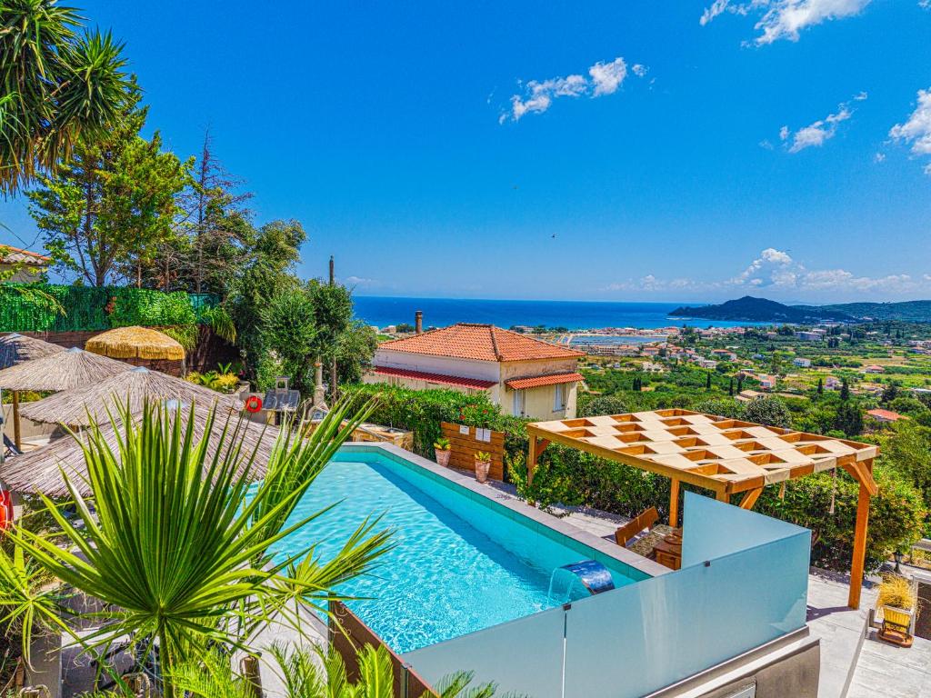 a villa with a swimming pool and a view of the ocean at Holiday Sea View Villas in Katastárion