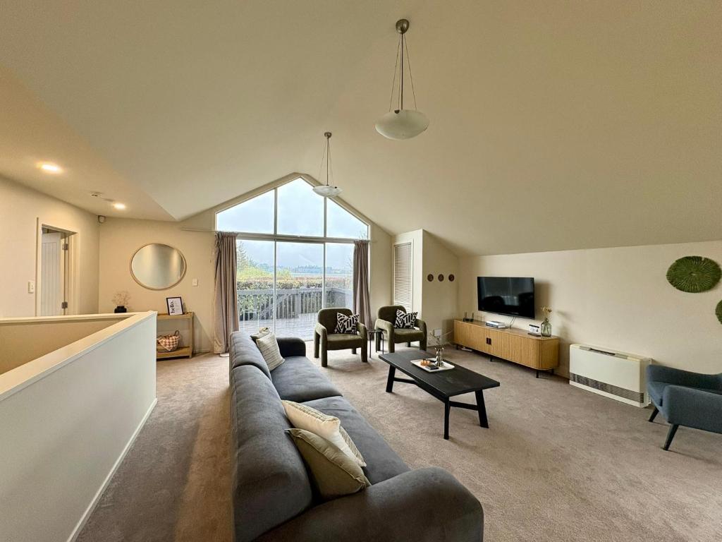 a living room with a couch and a table at Mountain Views on the Reserve in Wanaka