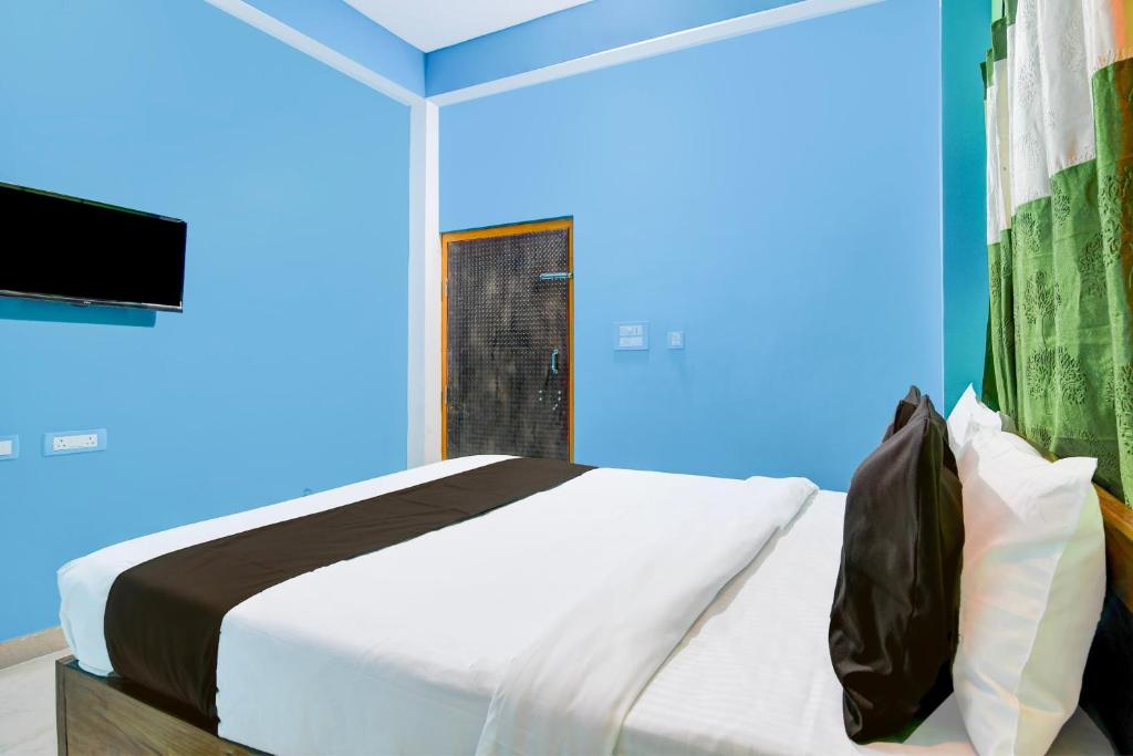a bedroom with a bed and a television in it at Hotel O Blue Valley in Khandagiri