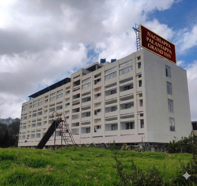 a white building with a sign on top of it at Nachiappa in Kodaikānāl