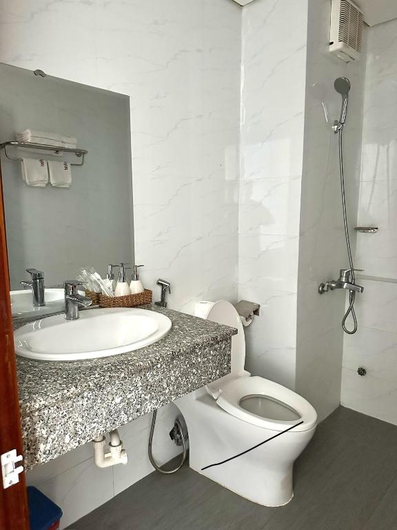 a white bathroom with a sink and a toilet at Phú An Hotel in Danang