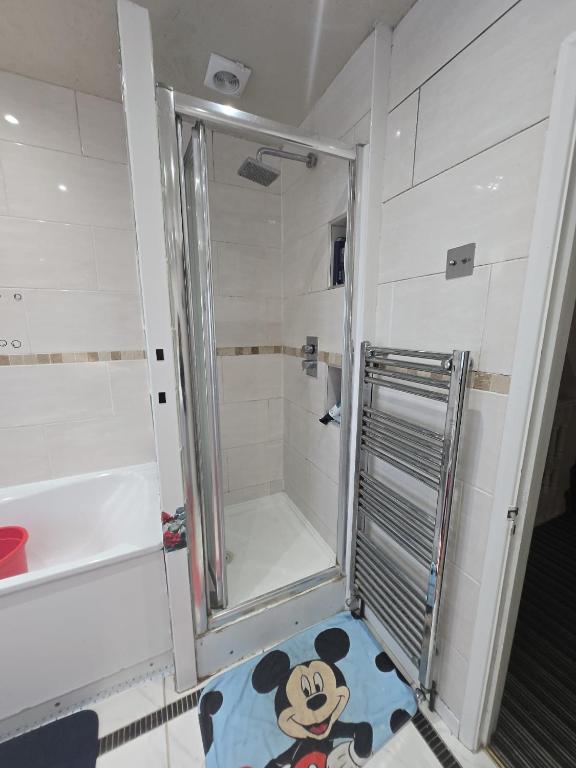 a shower with a glass door in a bathroom at Wembley Stadium Room with Parking and Breakfast in London