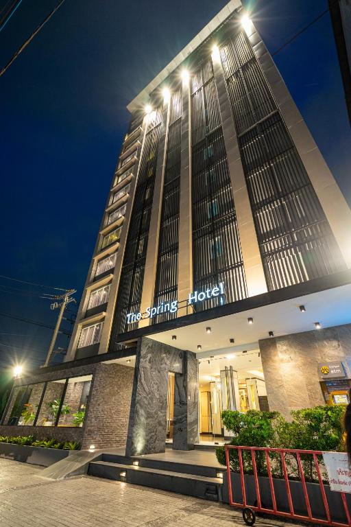 a tall building with a sign on it at night at The Spring Bangkok in Bangna