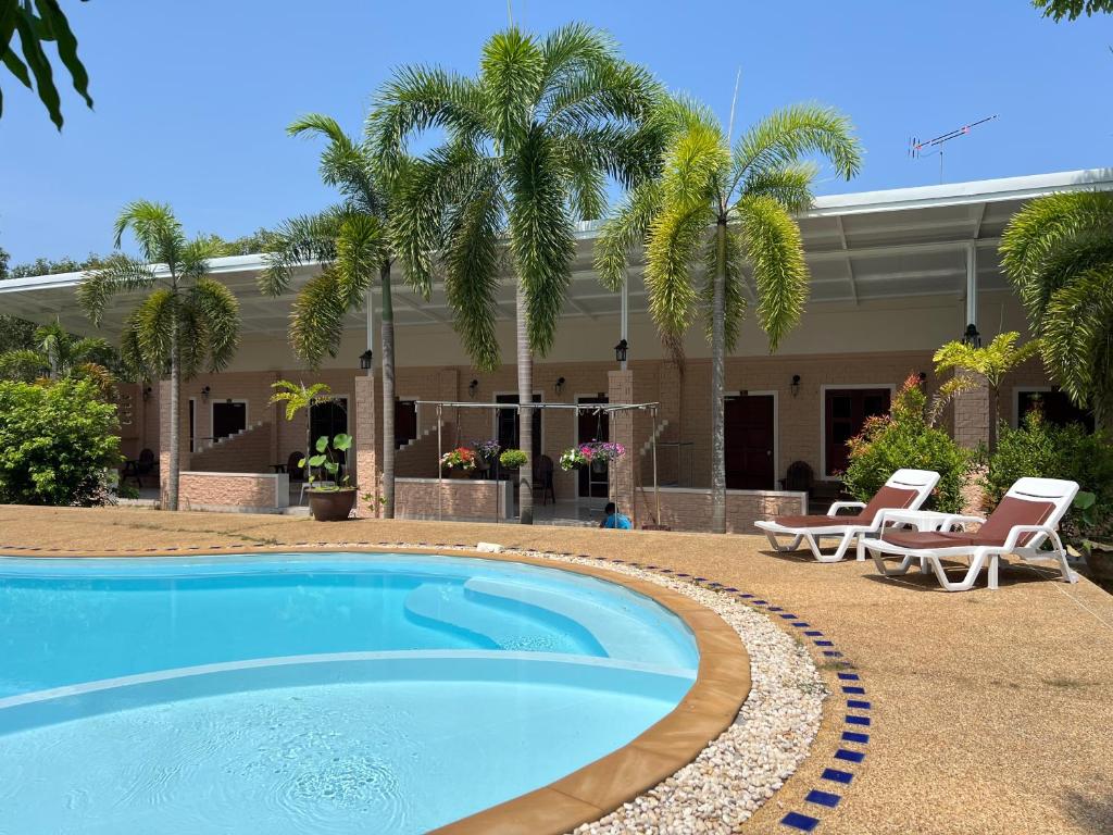a swimming pool in front of a house with palm trees at Krabi Discovery Resort in Tha Lane Bay