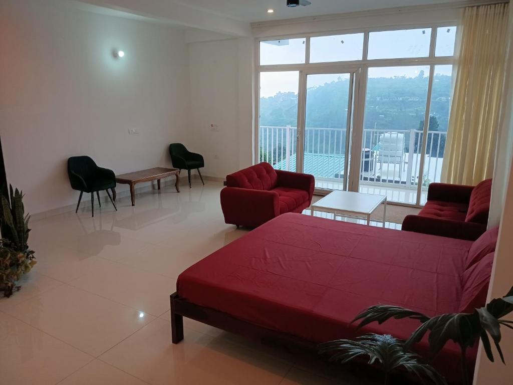 a living room with a red couch and a large window at JIJIVISHA Homestay in Bhīm Tāl