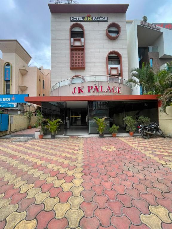 a uk palace building with a brick patio in front of it at Hotel JK Palace Newly Renovate in Shirdi