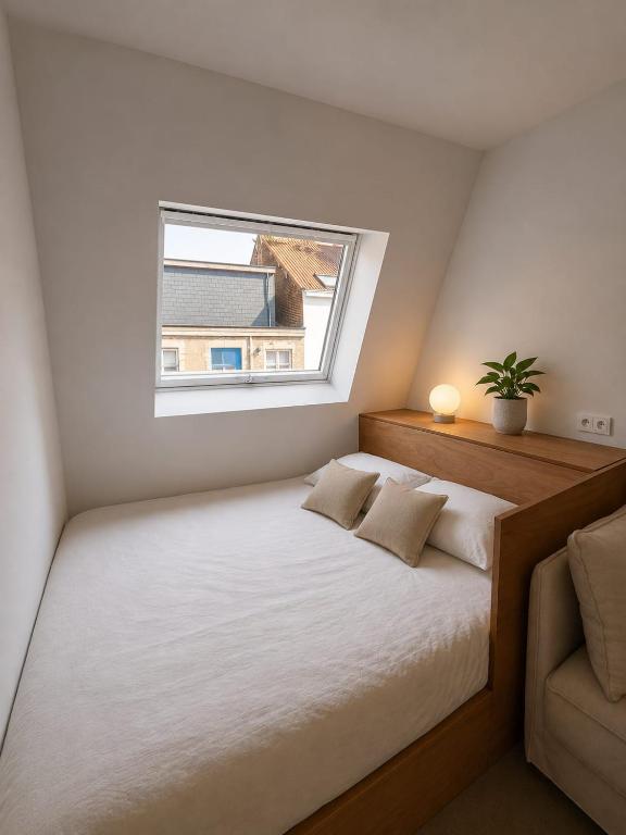a small bedroom with a bed and a window at Maison Bruxelles in Brussels