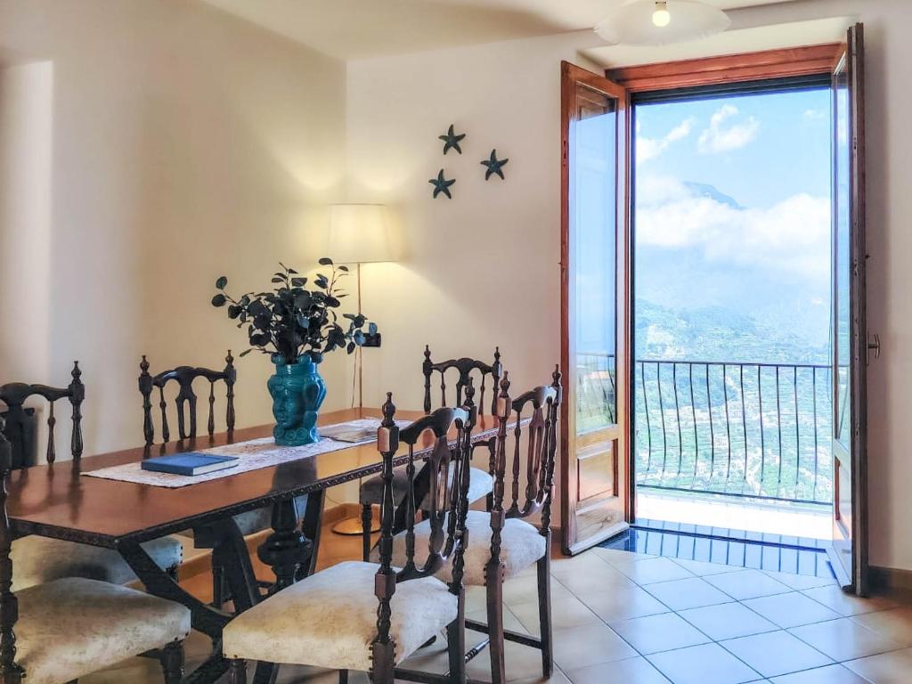 a dining room with a table and chairs and a window at Casa Rossa in Ravello