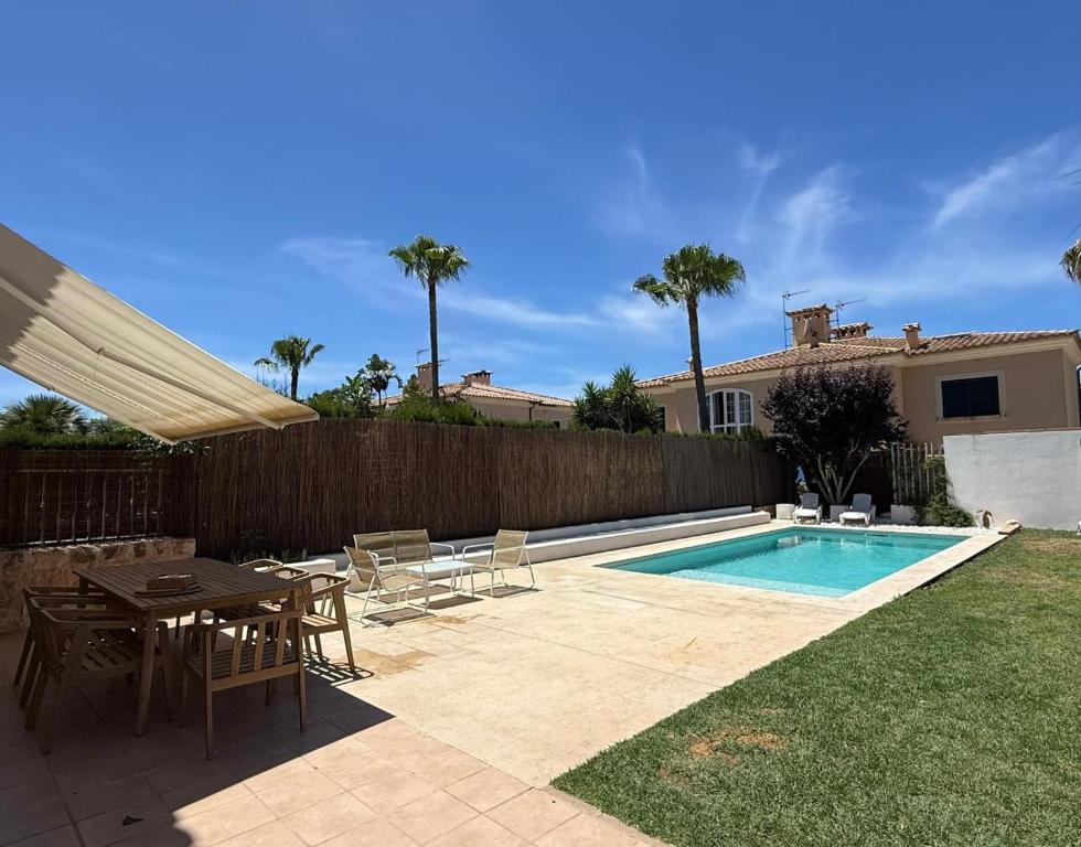 a patio with a table and chairs next to a swimming pool at Villa Mares Puig in Llucmajor
